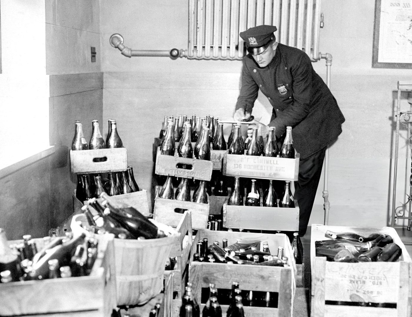 Police Officer C. Beckman Checks Out 450 Bottles Of Confiscated Home Brew During A Prohibition Raid On A Hotel, 1933.