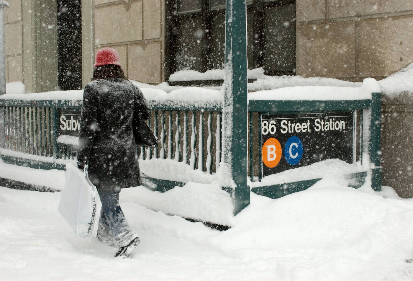 Woman Walking By Manhattan Subway Station During Winter Storm, 2006.