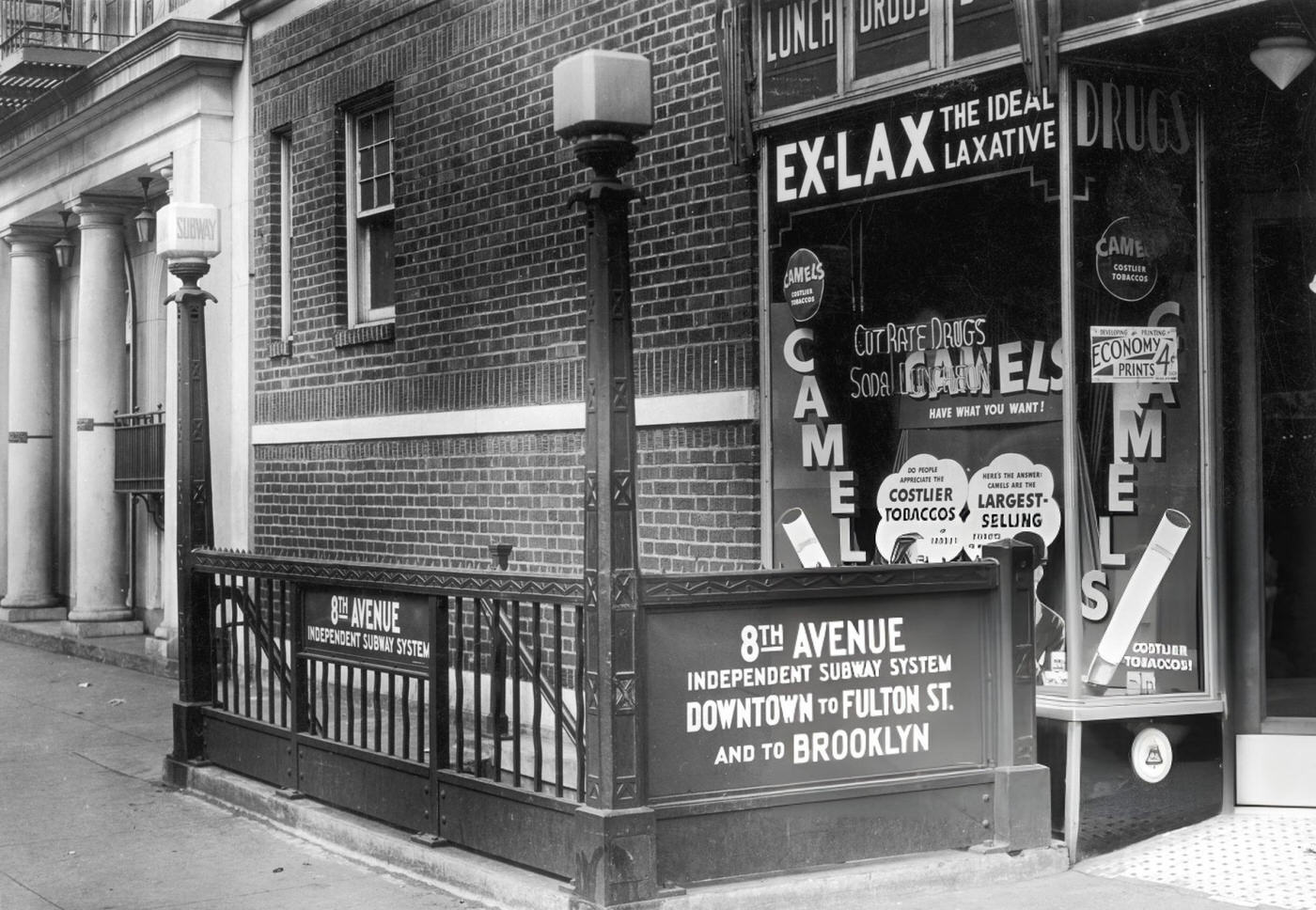Exterior View Of A Downtown Subway Entrance On Eighth Avenue, Next To A Small Drugstore, Manhattan, Circa 1935.