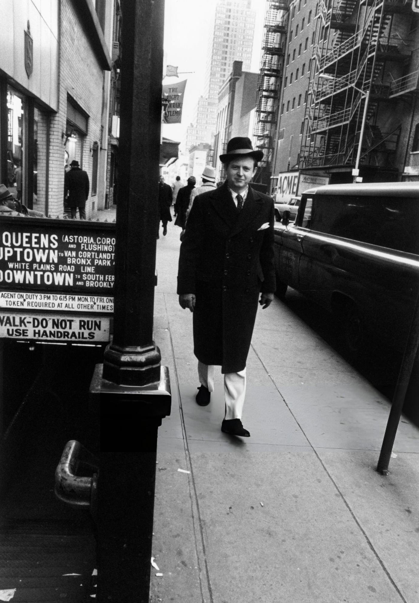 American Writer And Artist Tom Wolfe Walking In Front Of A Subway Entrance On A City Street, New York City, 1966.