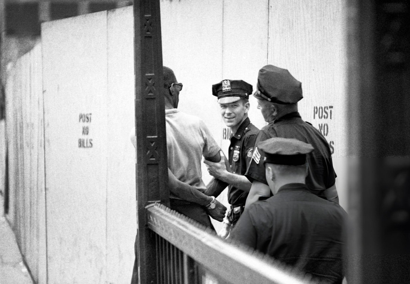 New York City Police Officers Escort An Arrested Man In Handcuffs From A Subway Exit, June 1969.