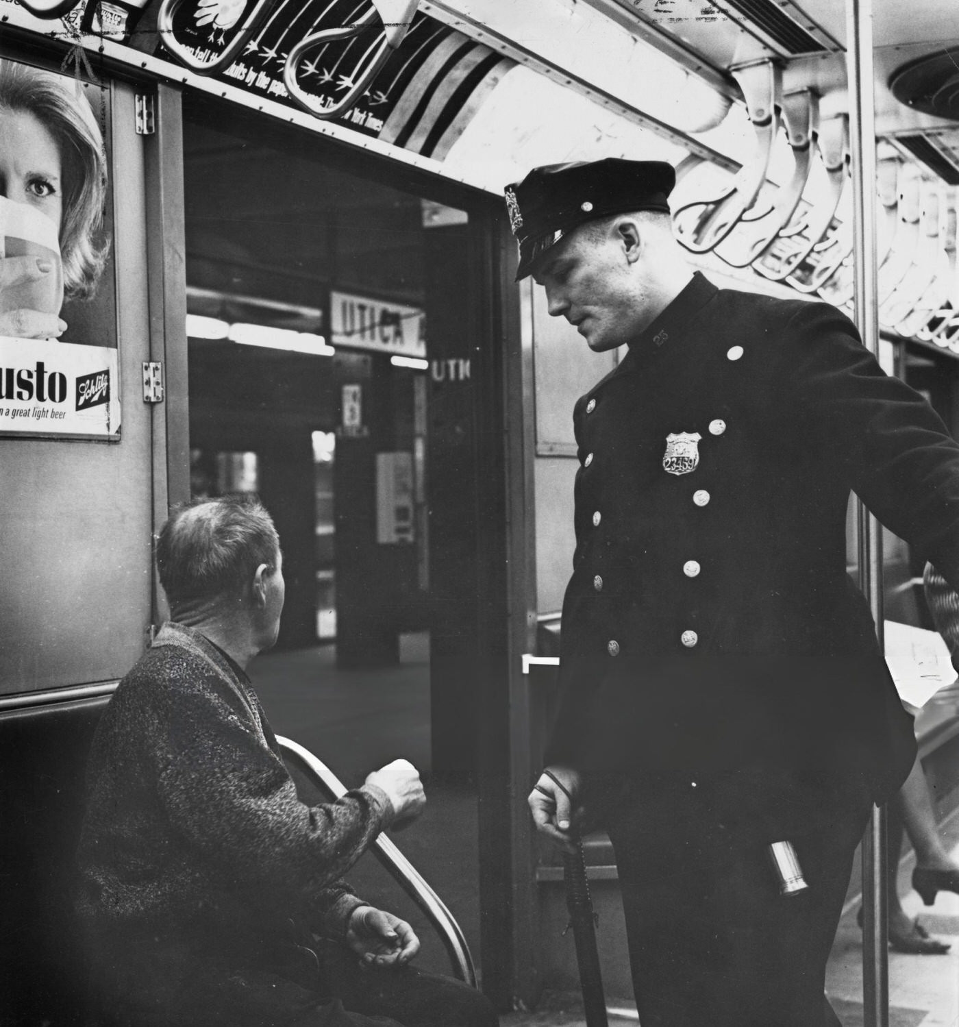 An Nypd Police Officer In Conversation With A Passenger On A Subway Train In New York City, Circa 1965.