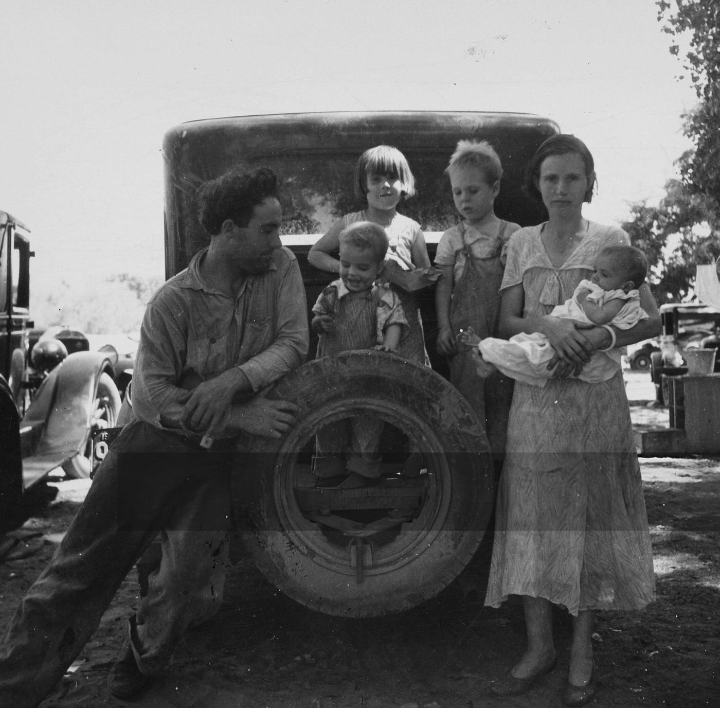Portrait Of A Migrant Worker With His Wife And Four Children, Resting On A Car, Marysville, California, 1935.