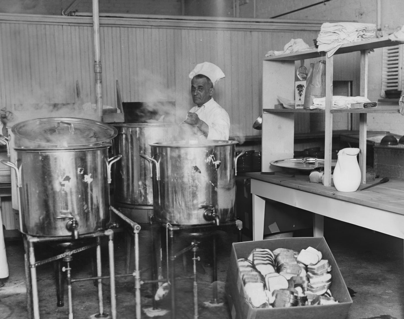A Cook Works Large Containers Of Soup In A Commercial Kitchen In New York City, Preparing Food For Distribution During The Depression, 1932.