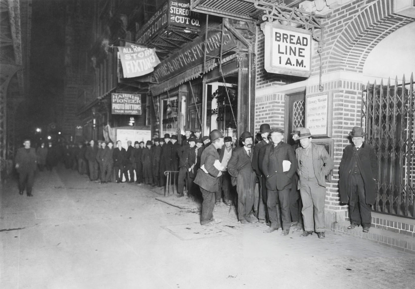 Relief Organization Bowery Mission In New York Supplies Bread For Tramps And Vagrants, With Homeless Men Queuing At Night.