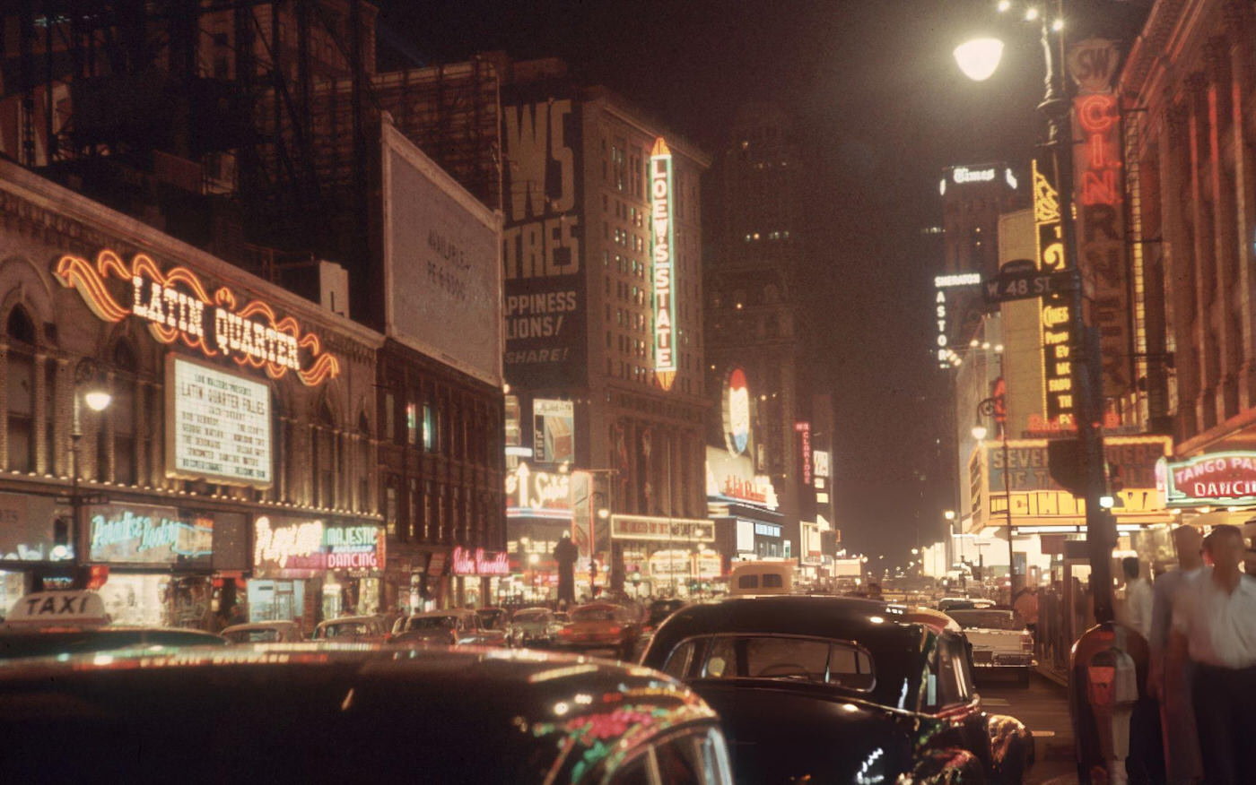 View Of Neon Signs Lit Up At Night In Times Square, Facing South On Seventh Avenue From West 48Th Street, Circa 1955.