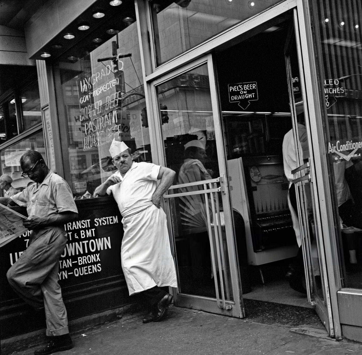 A Delicatessen Owner Taking A Break, Stands Outside His Store In Times Square, June 1, 1967.