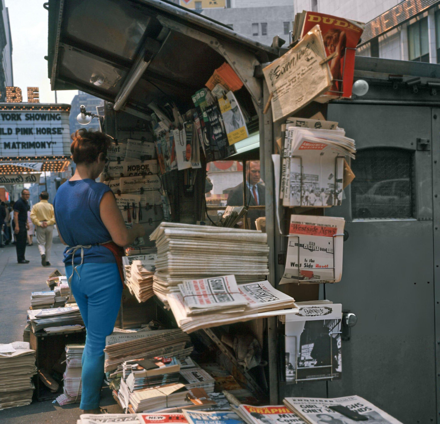 A Female Newspaper Vendor Stands In Front Of A News Stand In Times Square, September 1, 1967.