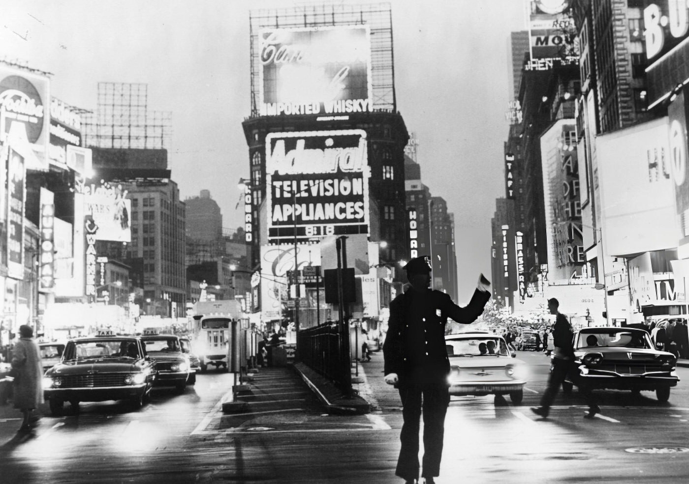 A Policeman Directs Traffic In Front Of The Neon Billboards Of Times Square, Circa 1965.