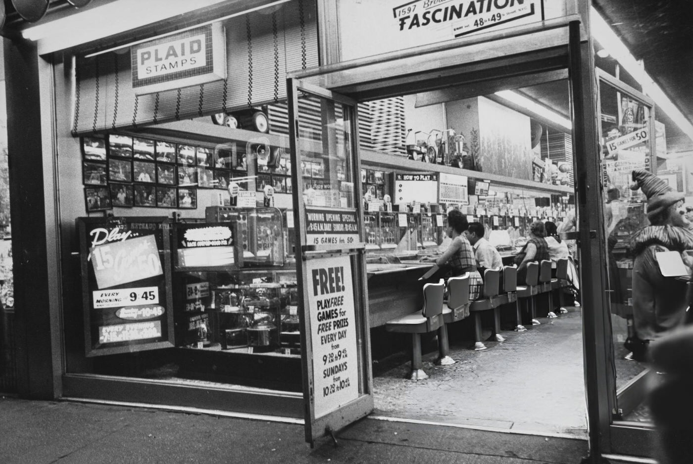 People Sitting At Pinball Machines In An Amusement Arcade In Times Square, Circa 1965.