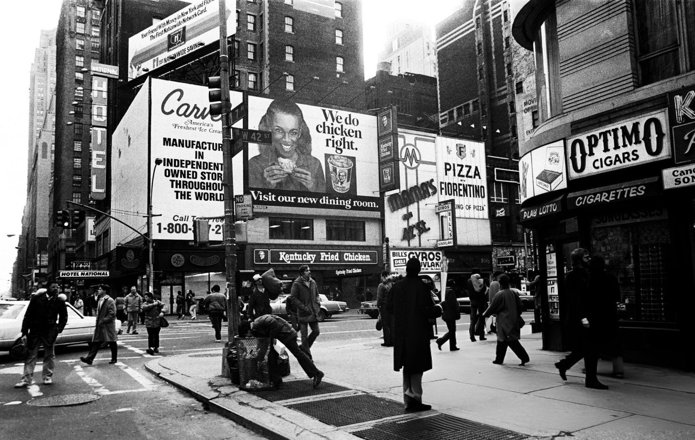 Foot Traffic As A Man Takes Something Out Of A Garbage Can At The Intersection Of 7Th Avenue And 42Nd Street In Times Square, January 26, 1984.