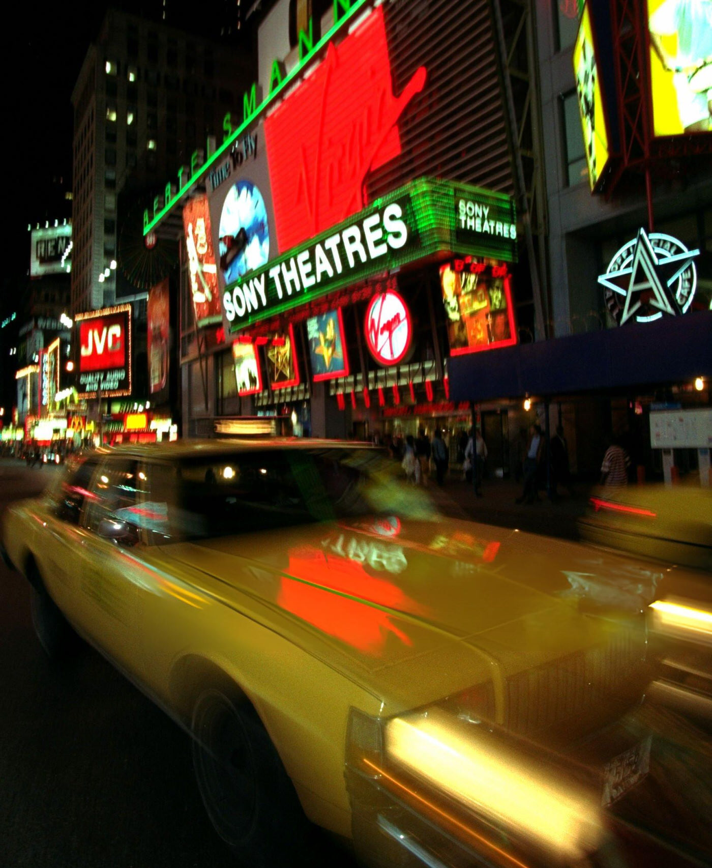 A Taxi Cab Zooms Down Seventh Avenue Past The Virgin Megastore In Times Square.