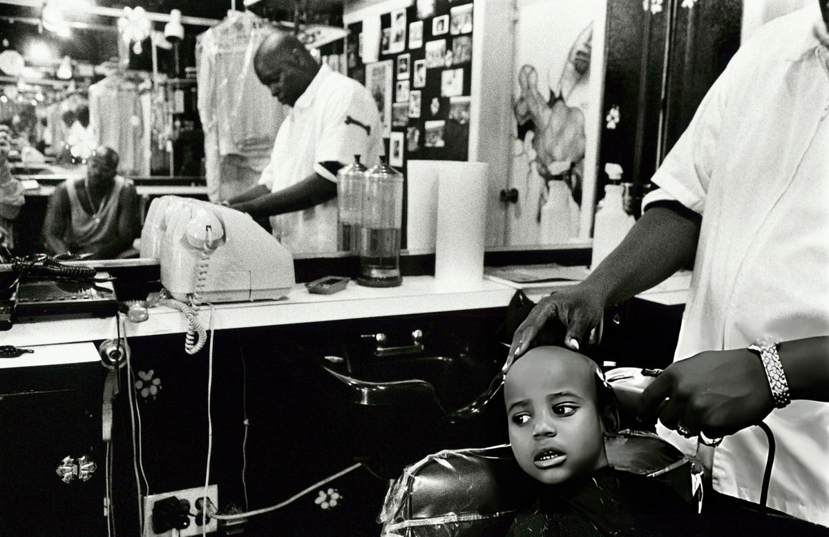 Barber Cutting A Child'S Hair In Harlem, New York.