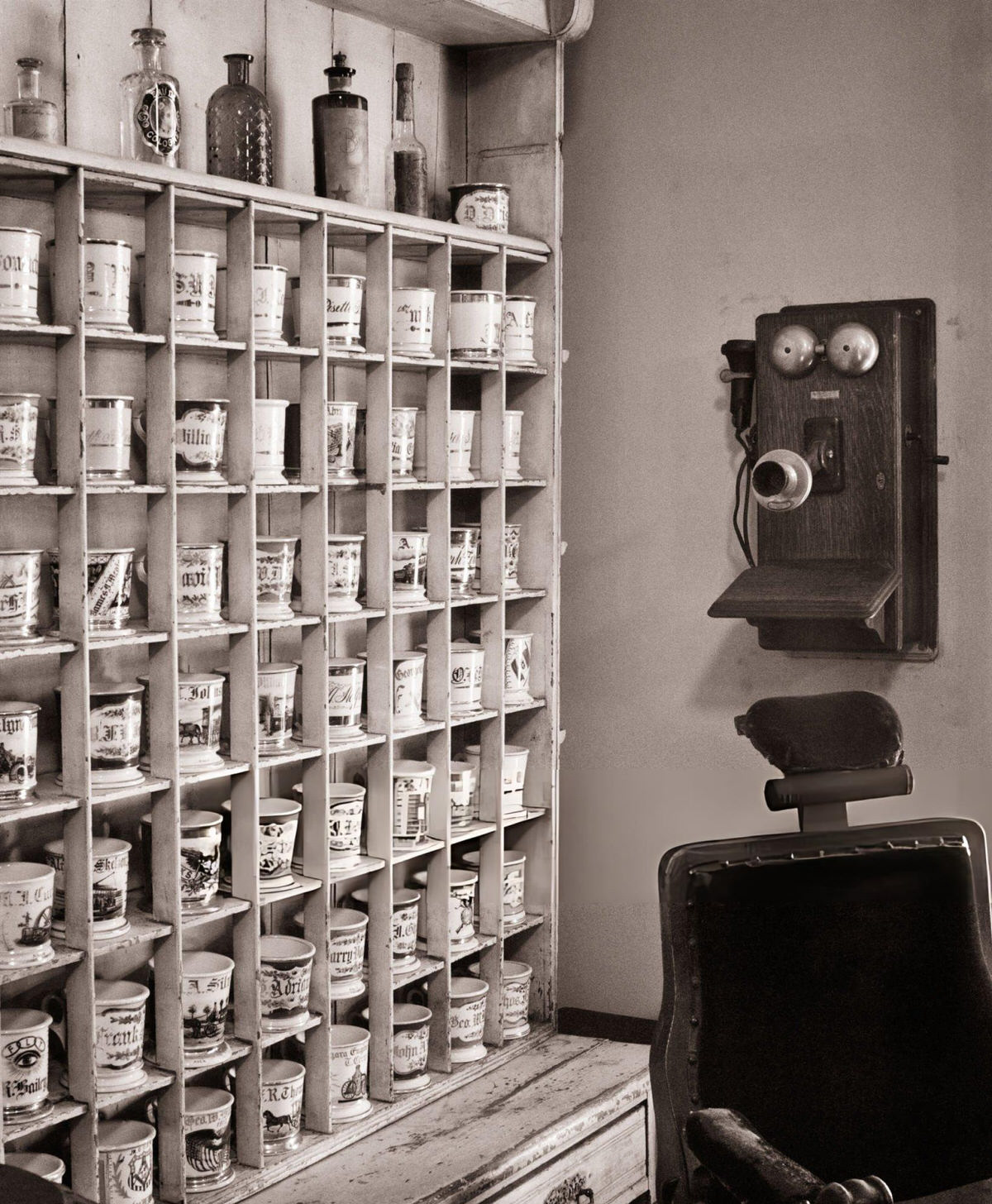 Antique Barber Shop Rack Of Personal Shaving Mugs And A Wall Phone In Richmondtown, Staten Island, 1910S.