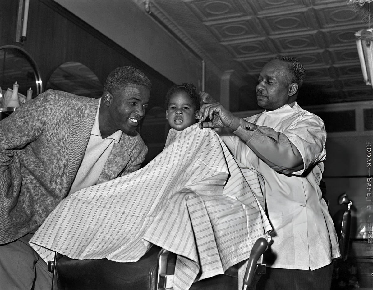 Jackie Robinson Taking His Son Jackie Jr. To A Barber Shop, Brooklyn, 1949.