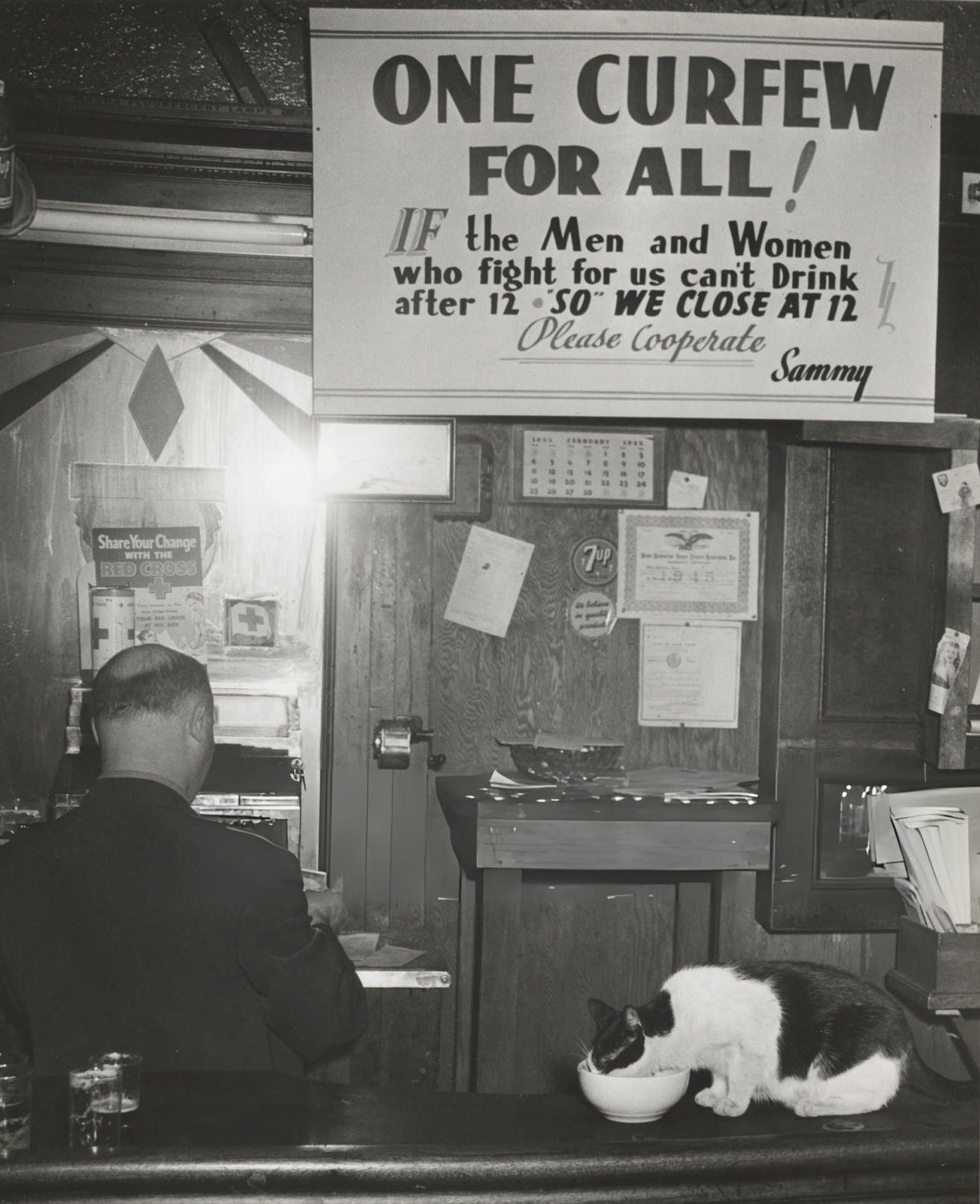 Sammy Fuchs At The Cash Register In Sammy'S Bowery Follies With A Sign Regarding The Wartime Curfew, New York, 1945.