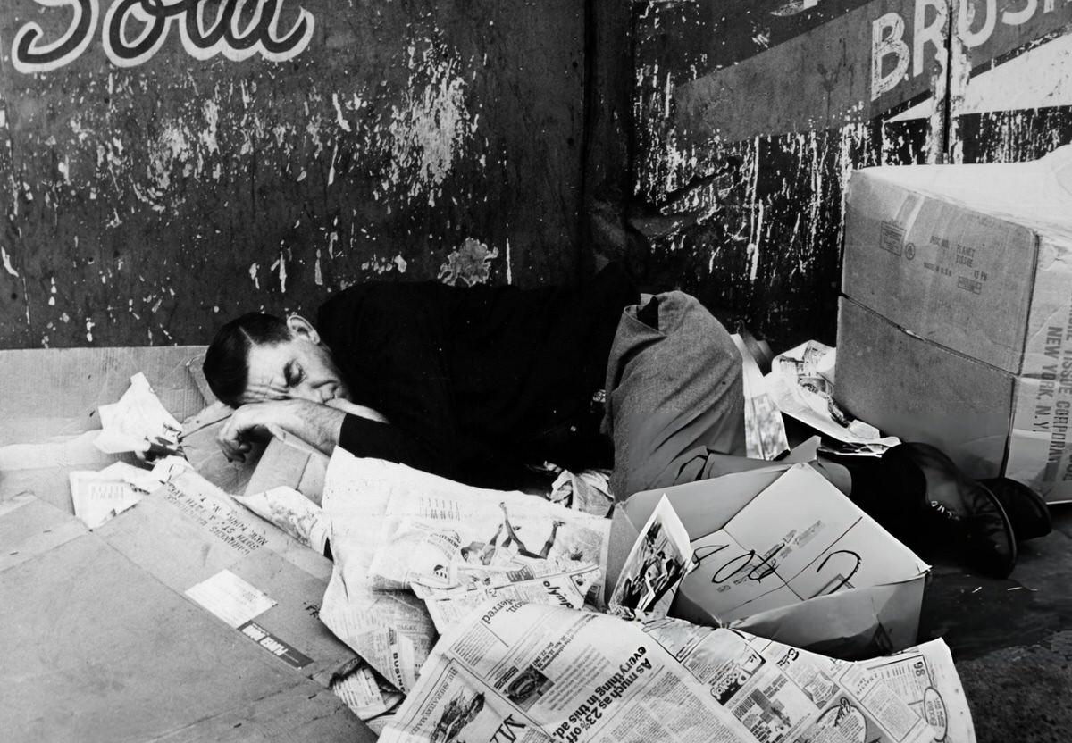 Homeless Man Sleeping On Newspapers And Cardboard In The Bowery, New York, 1970.