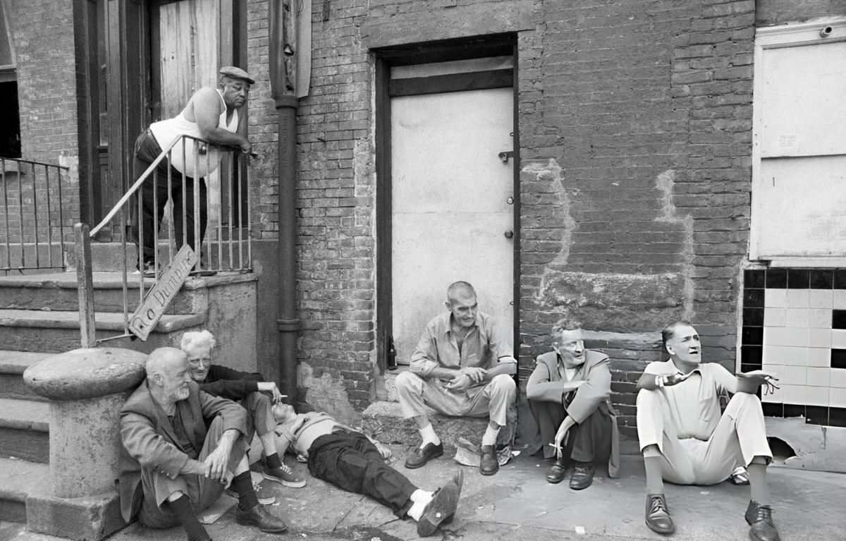 Men Sitting Against A Tenement Building In The Bowery, New York, 1972.