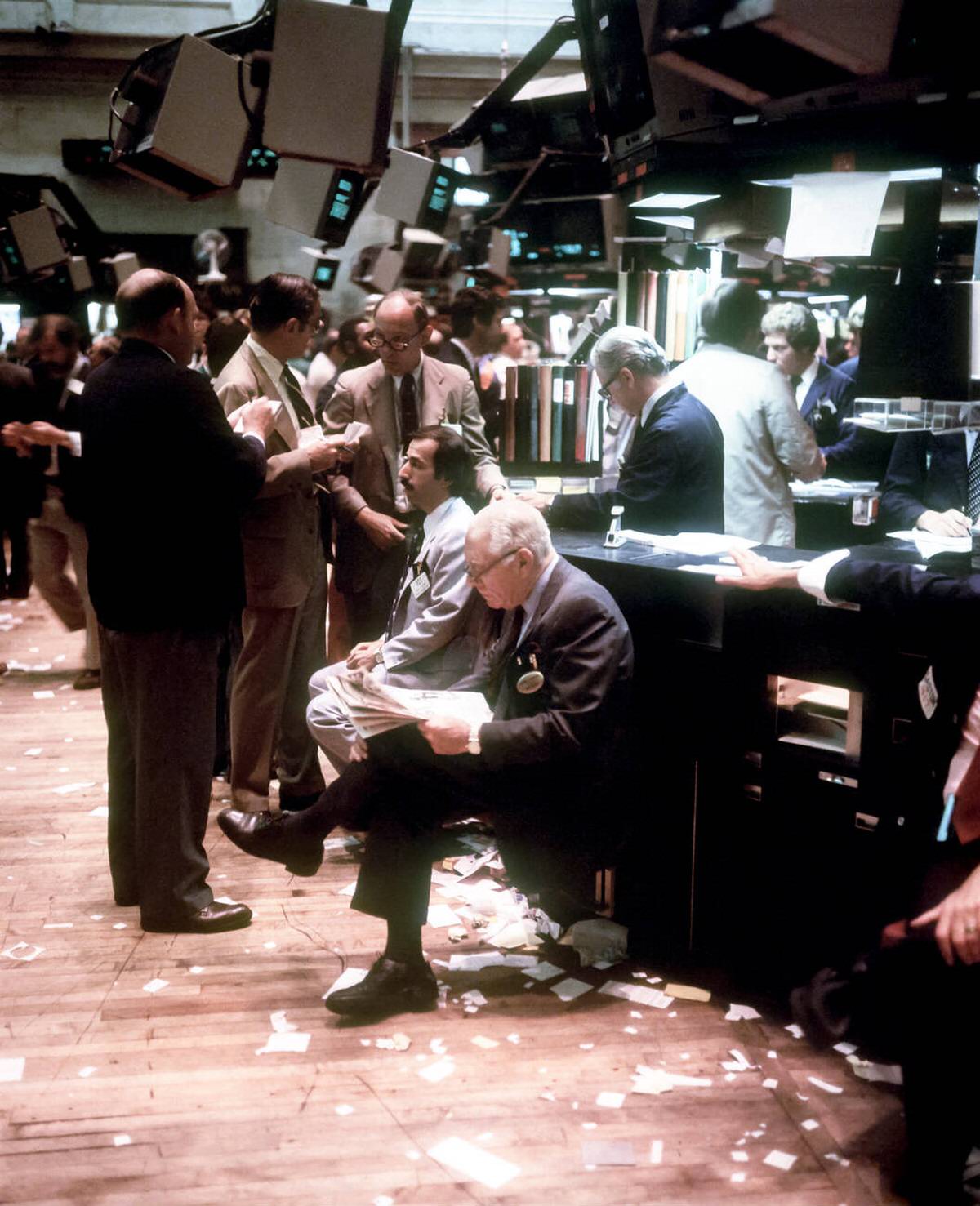Broker Reading A Financial Paper On The New York Stock Exchange Trading Floor, 1982.