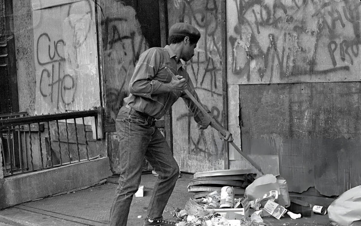 Young Lords Party Co-Founder Felipe Luciano Sweeping Trash During The Garbage Offensive In El Barrio, East Harlem, 1969.