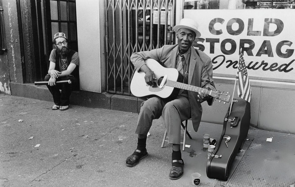 Elderly Man Playing Guitar On A Street In Greenwich Village, 1970.