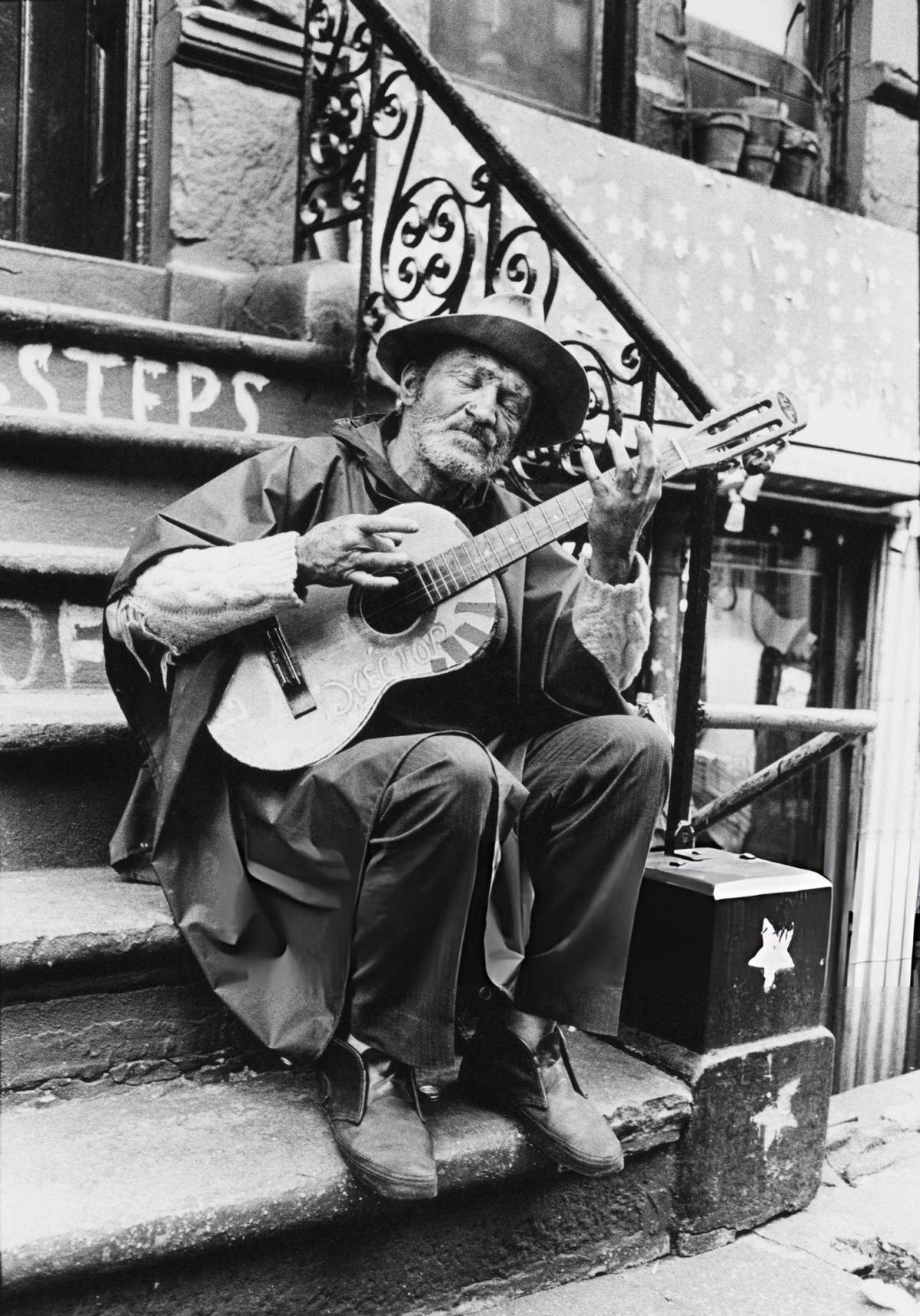 Man Playing Guitar On The Steps Of A Building On Macdougal Street, 1972.
