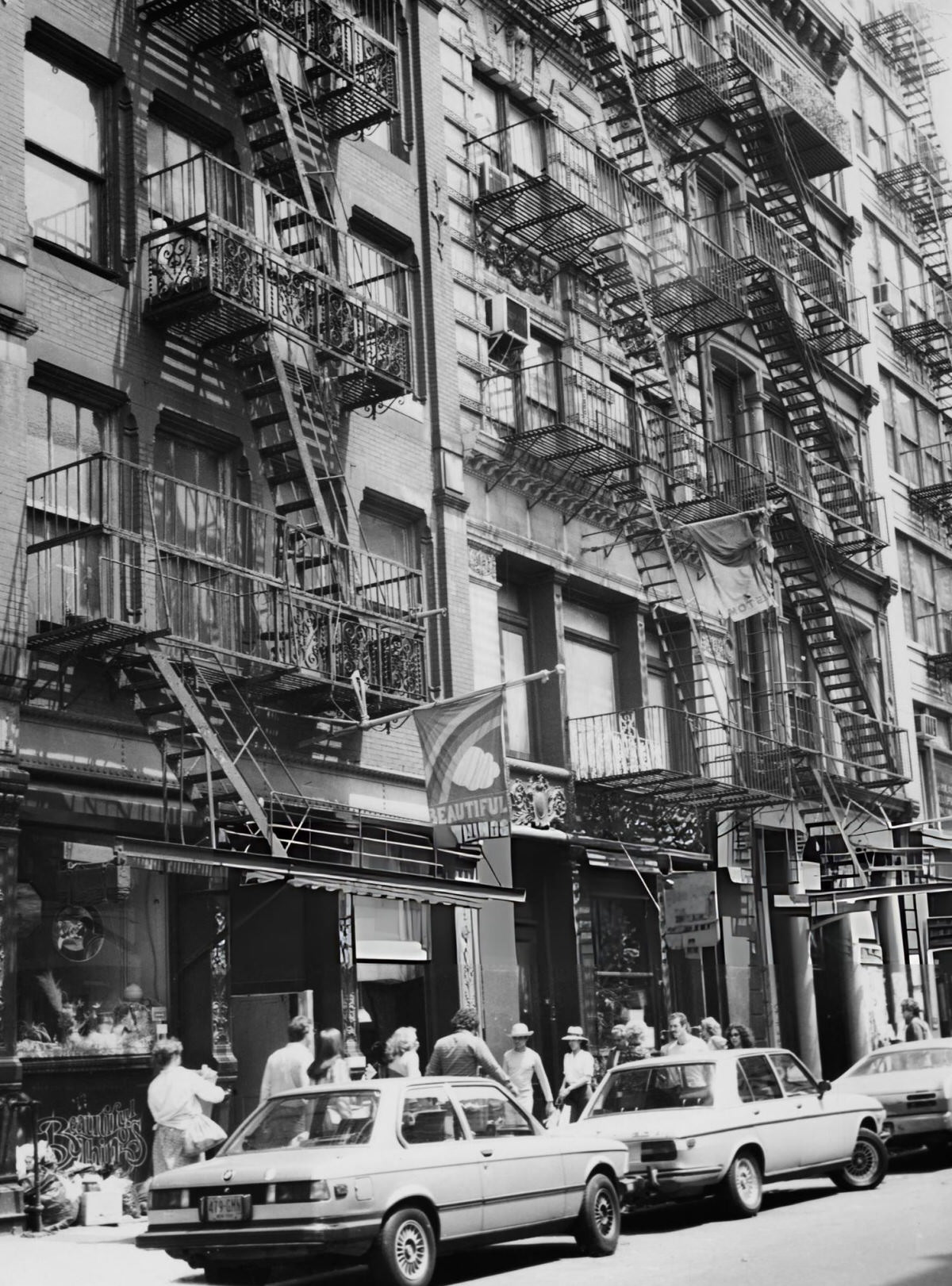 Pedestrians And Parked Cars Under Fire Escapes In Greenwich Village, 1980.