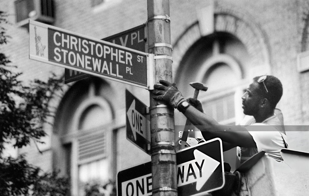 Traffic Worker Changing A Street Sign To Christopher Street/Stonewall Place, Greenwich Village, 1989.