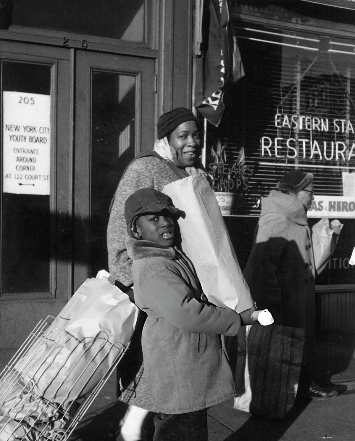 Mother And Son With Shopping On A Harlem Sidewalk, 1956.