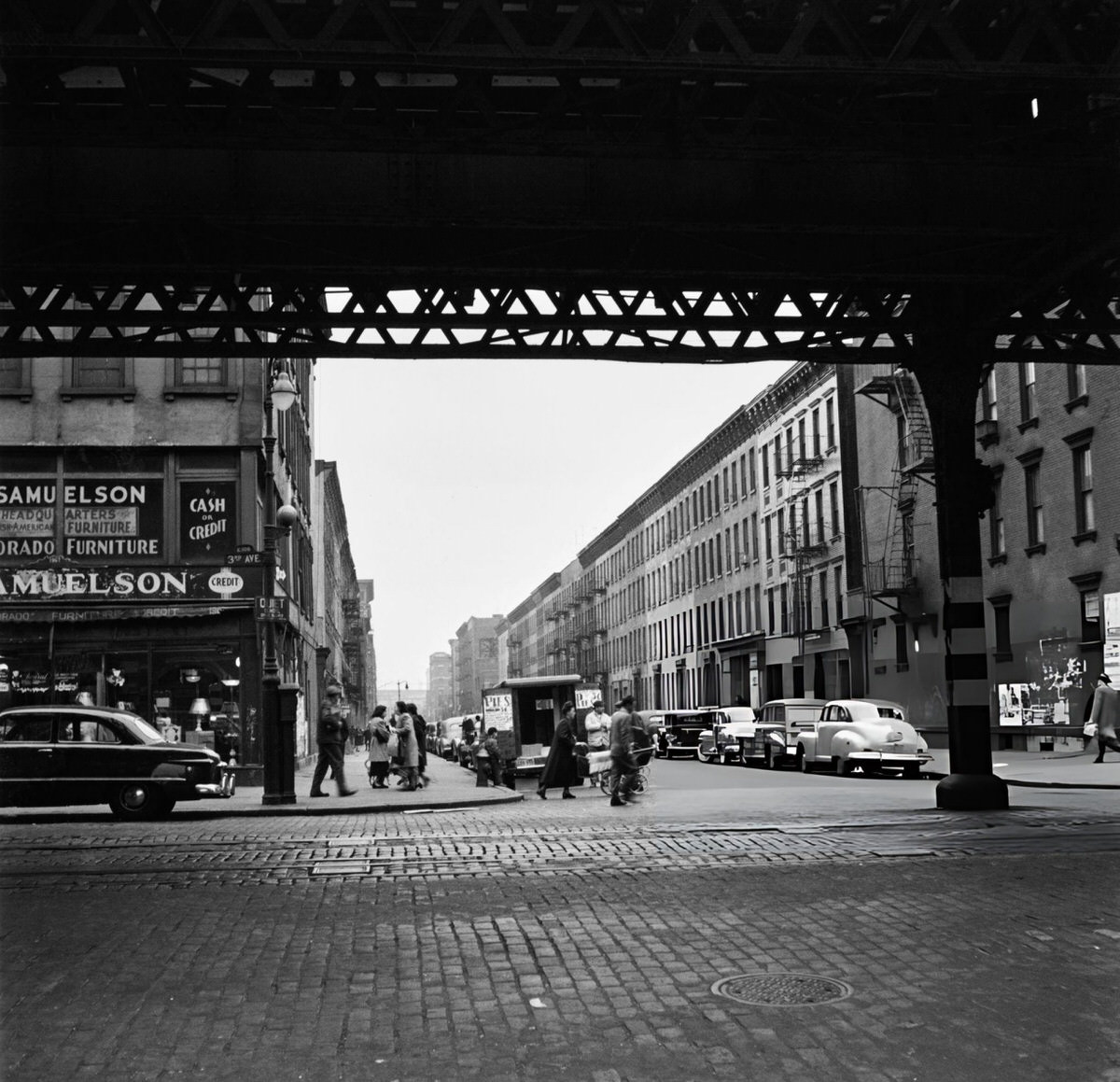 Intersection Under An Elevated Train Track With A Pie Vendor, Harlem, 1950.