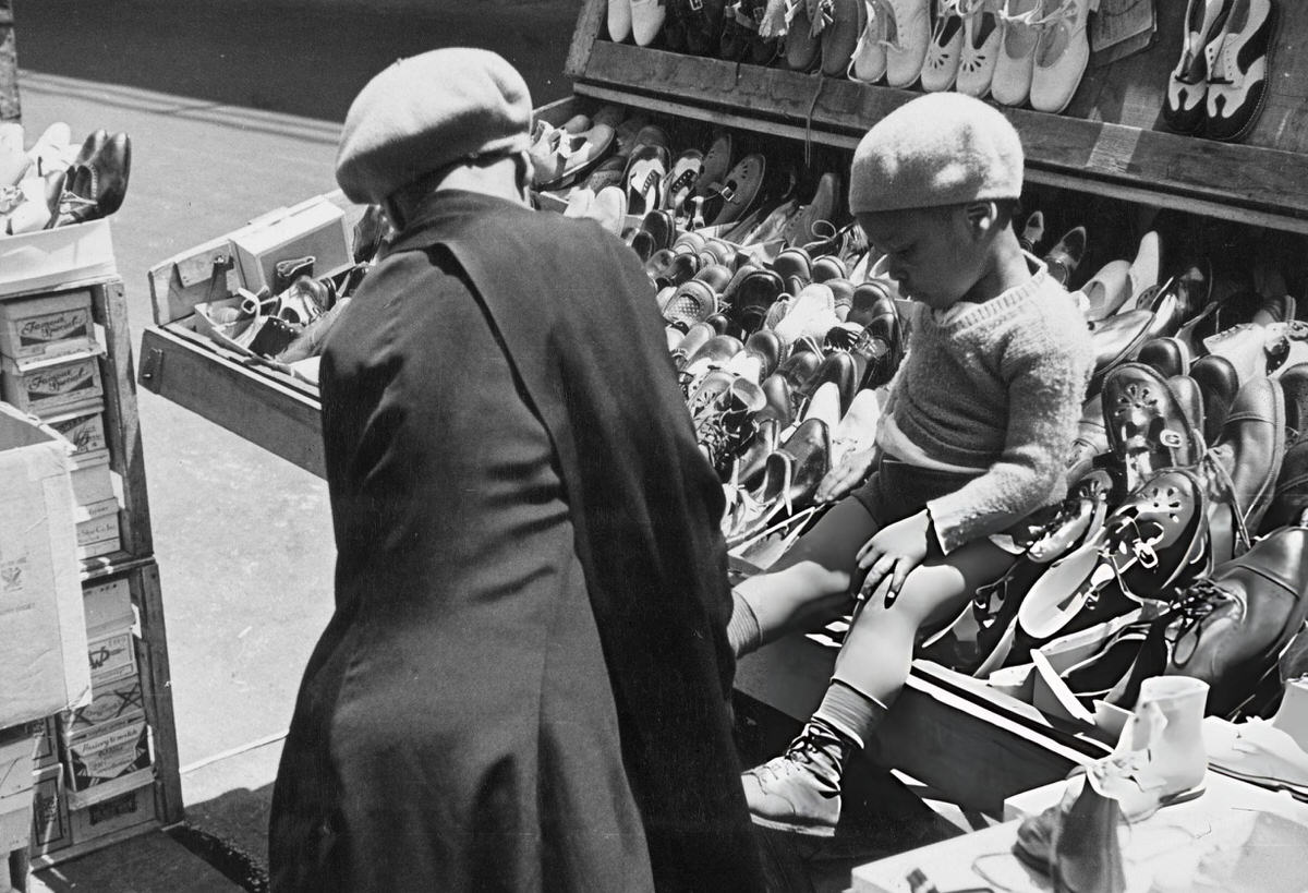 Boy Shopping For Shoes At A Market Stall, Harlem, 1950.