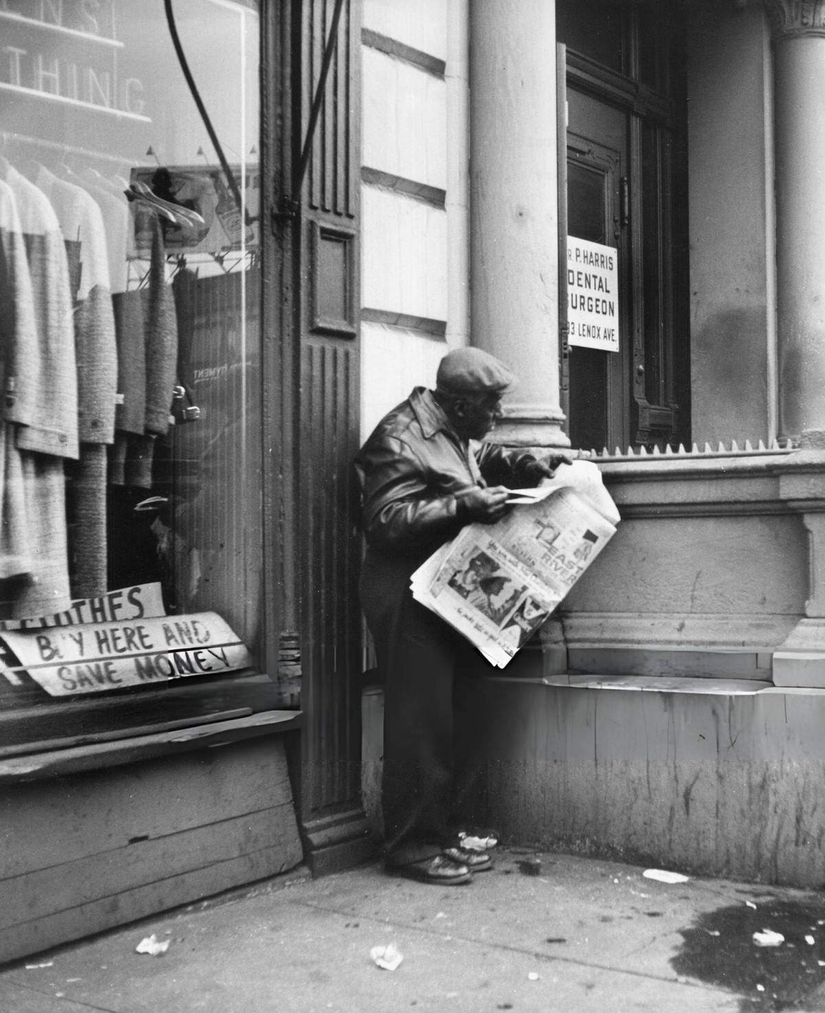 Man Reading The Newspaper Near A Clothes Shop, Harlem, 1956.