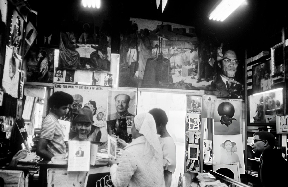 Customers In A Shop With Posters Of Mao Zedong And Malcolm X, Harlem, 1970.