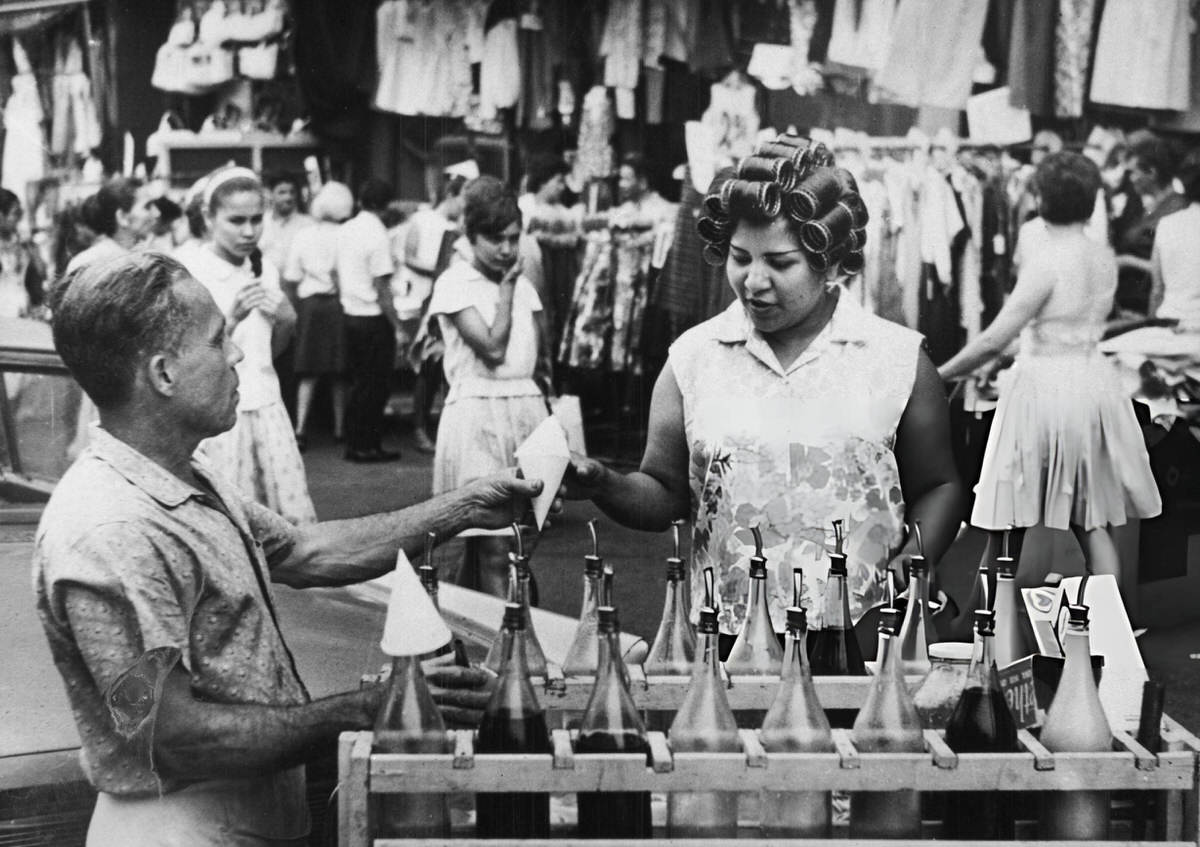 Woman Buying Shaved Ice From A Street Vendor, Harlem, 1975.