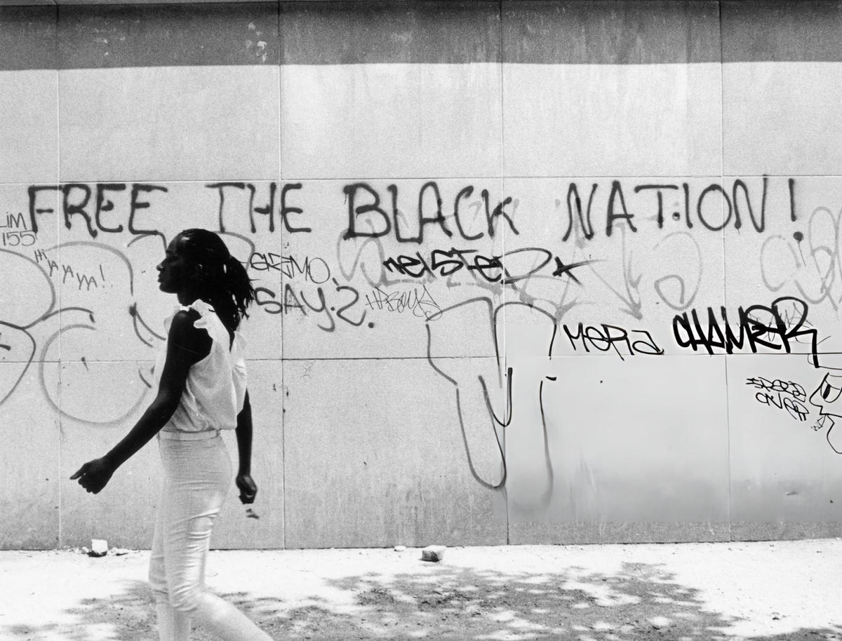 Woman Walking Past A Wall With &Amp;Quot;Free The Black Nation!&Amp;Quot; Graffiti On Lenox Avenue, Harlem, 1985.