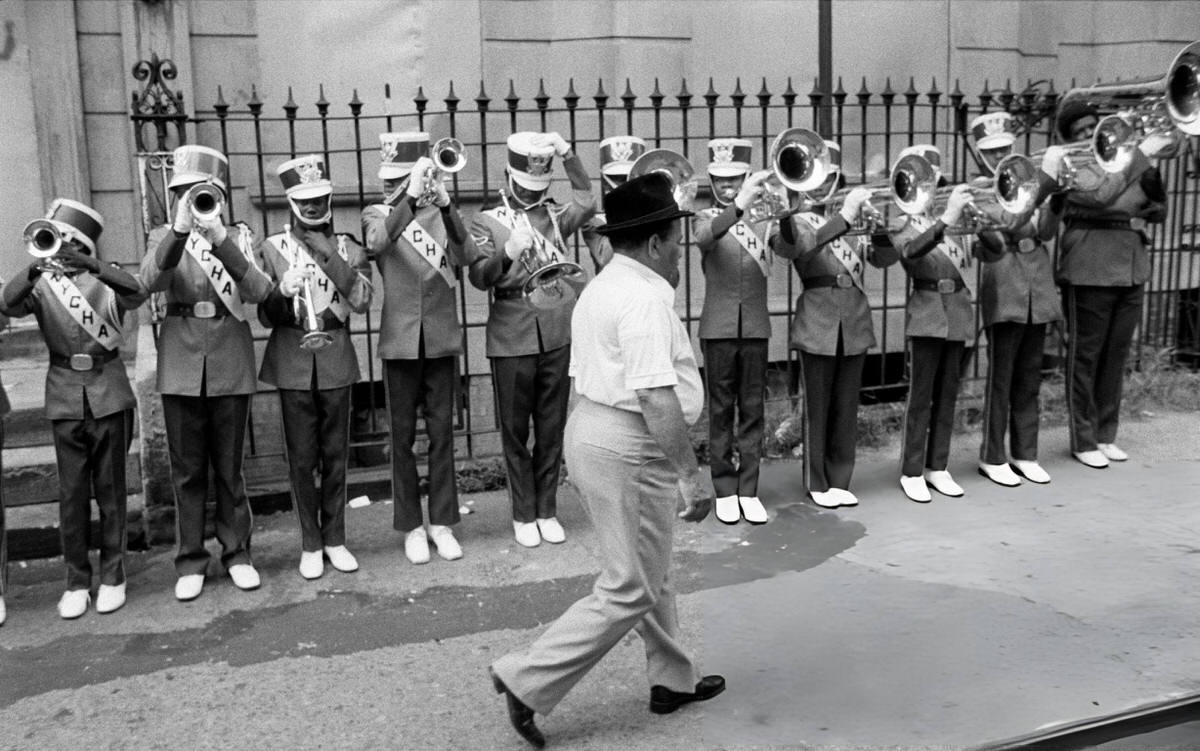 Man Walking Past A Junior Brass Band During Afro-American Day In Harlem, 1980.
