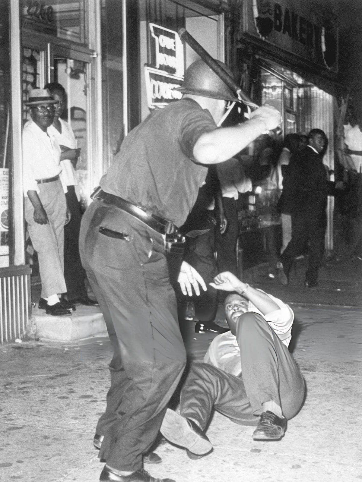 Police Officer Beating A Protester With A Nightstick During The Harlem Riots, 1964.