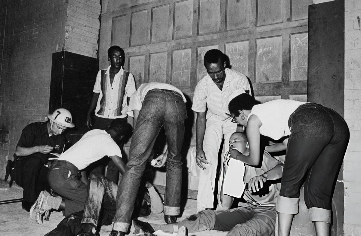 Police Officer Attending To Injured Bystanders On 124Th Street During The Harlem Riots, 1964.