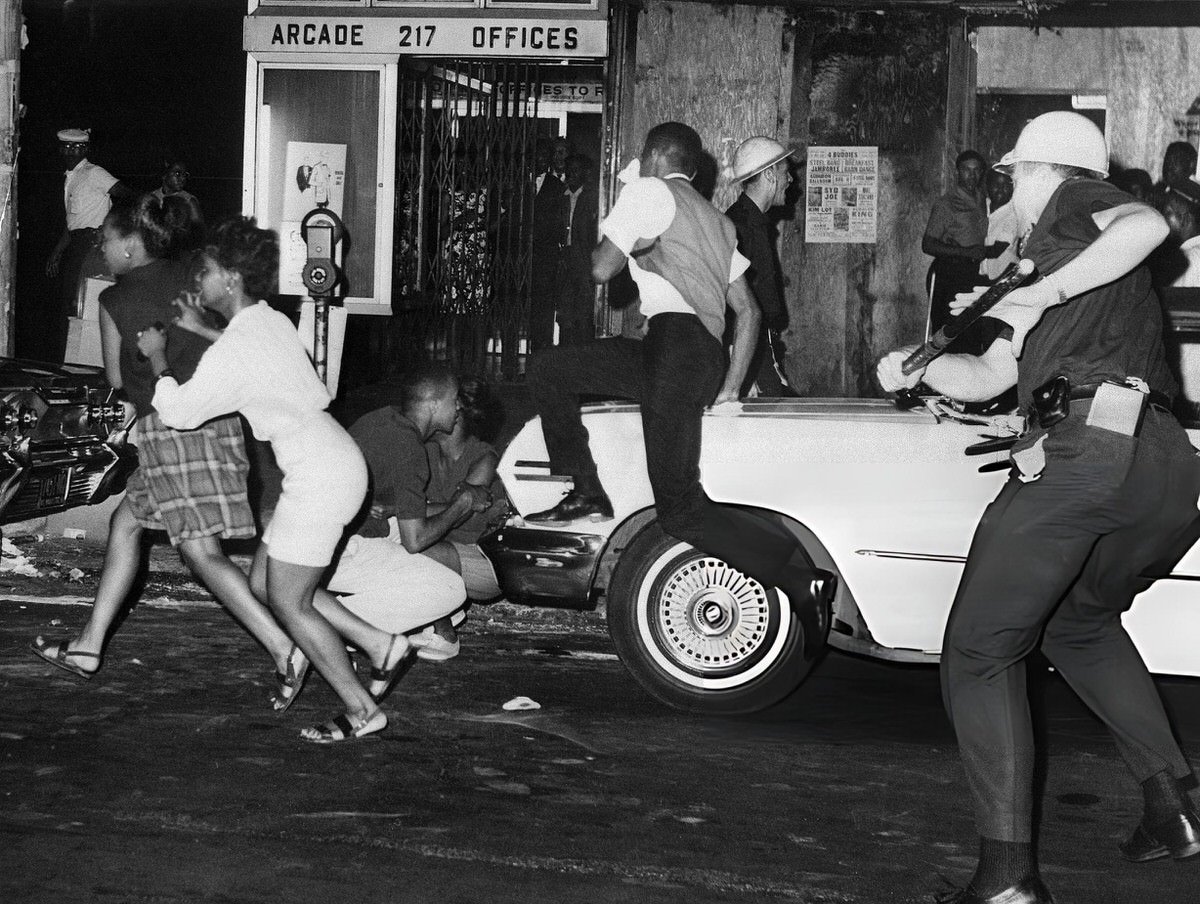 Police Officer Using A Billy Club Against Youths During The Harlem Riots, 1964.