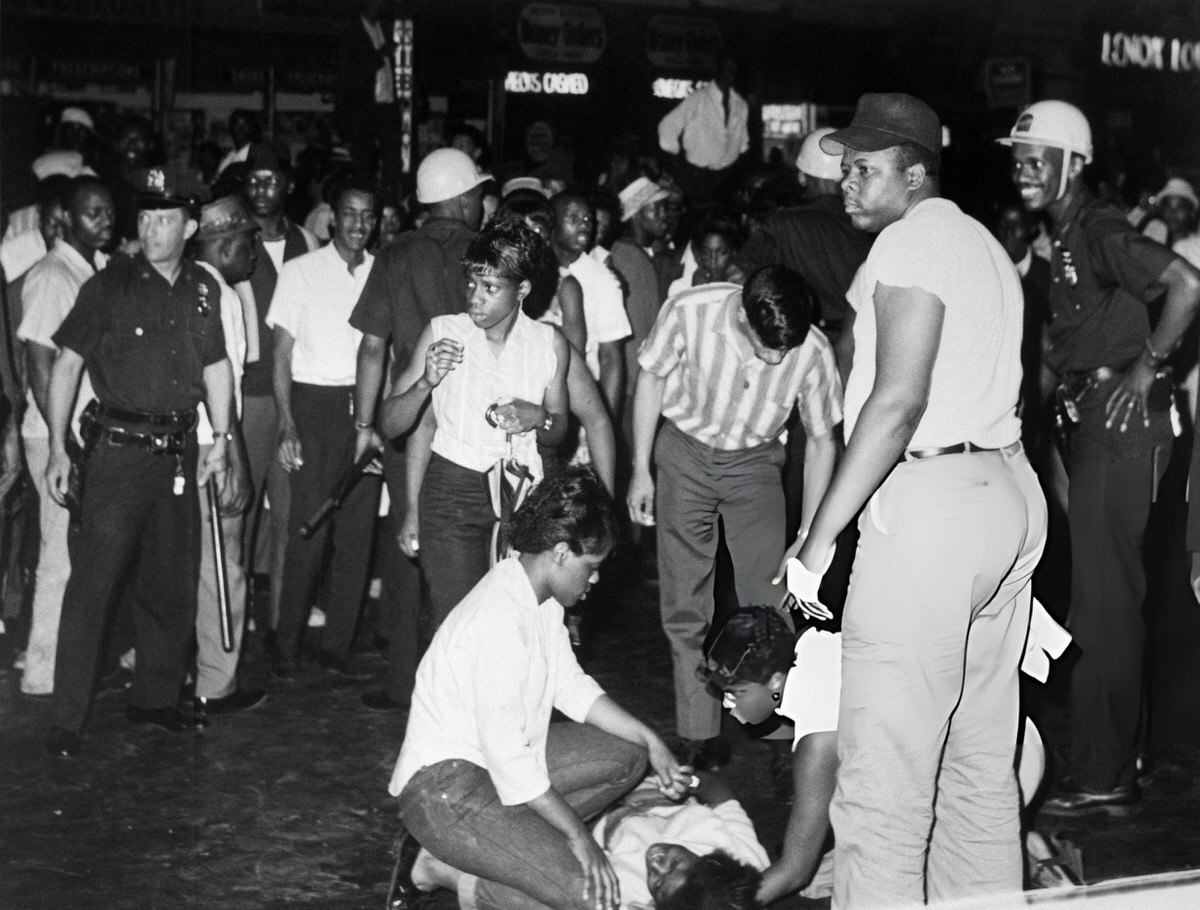 People Assisting An Injured Woman During The Harlem Riots, 1964.