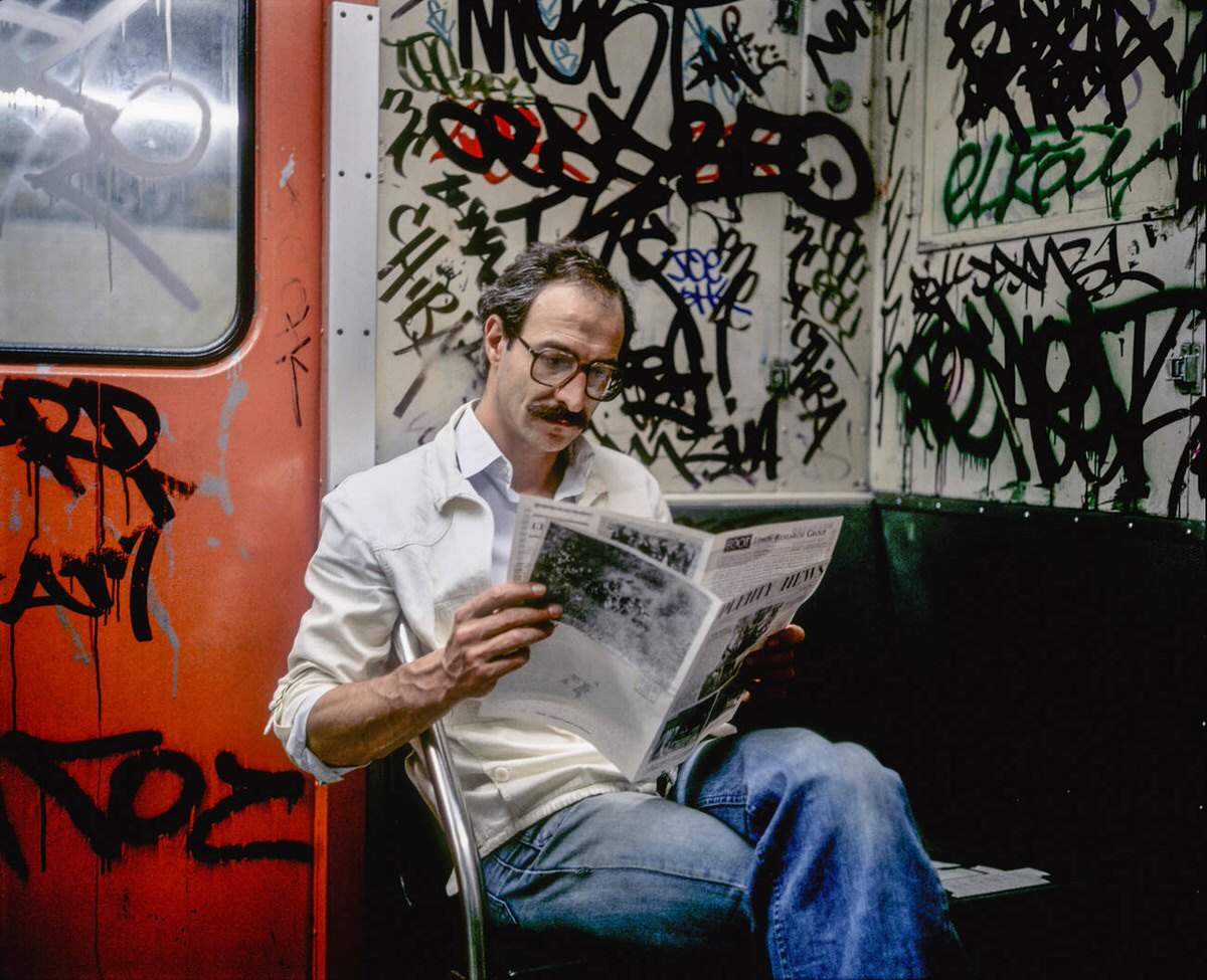 Passenger Reading A Newspaper In A Graffiti-Covered Subway Carriage, Manhattan, 1982.
