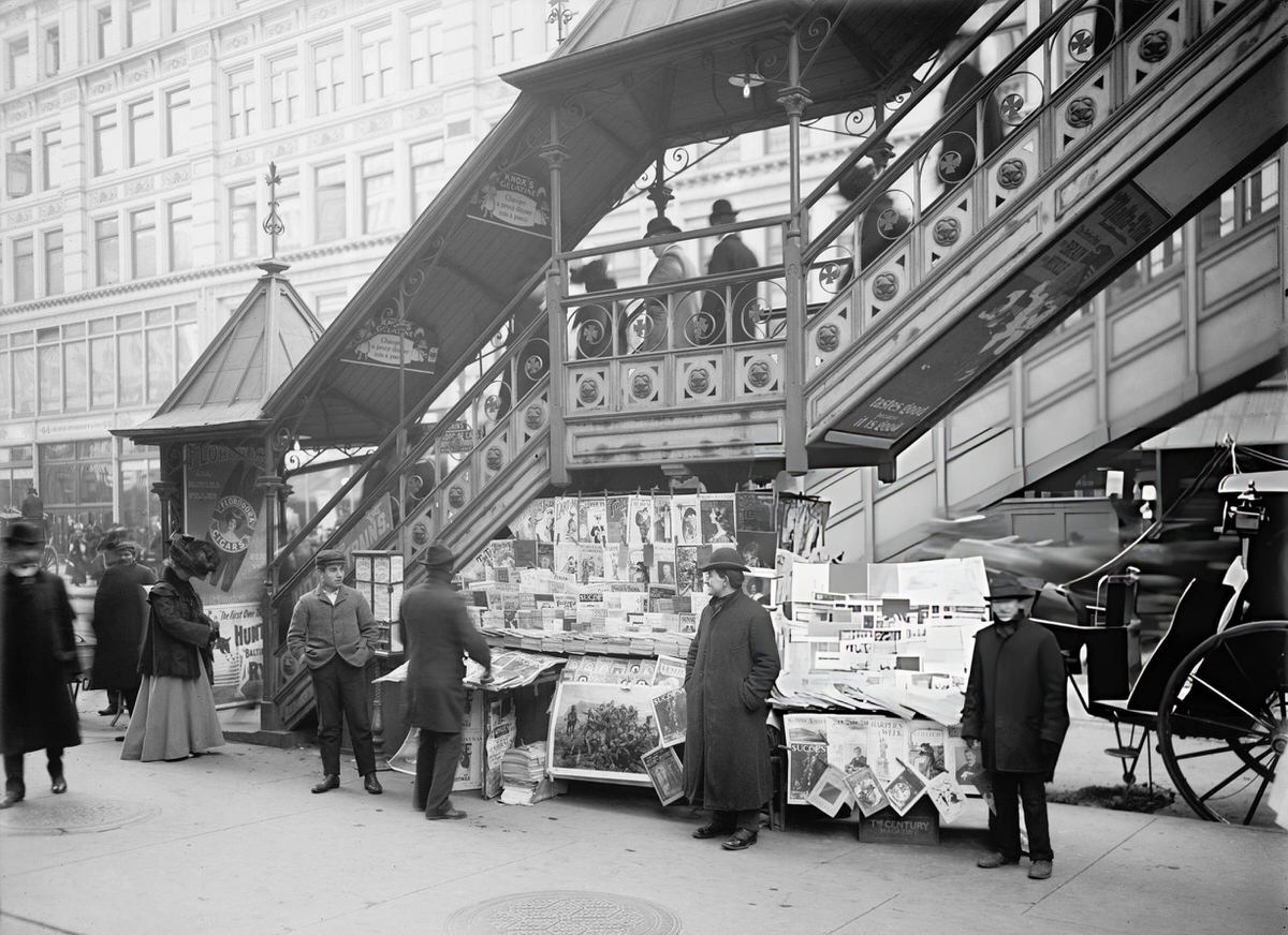 Newspaper Vendor At An Elevated Train Stairway, New York, 1903.