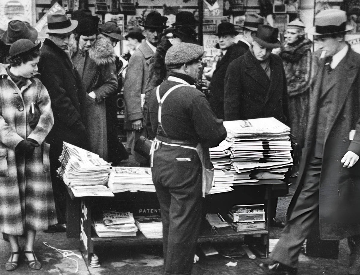 Pedestrians At A Newsstand On 5Th Avenue And 42Nd Street Scanning Headlines, New York.