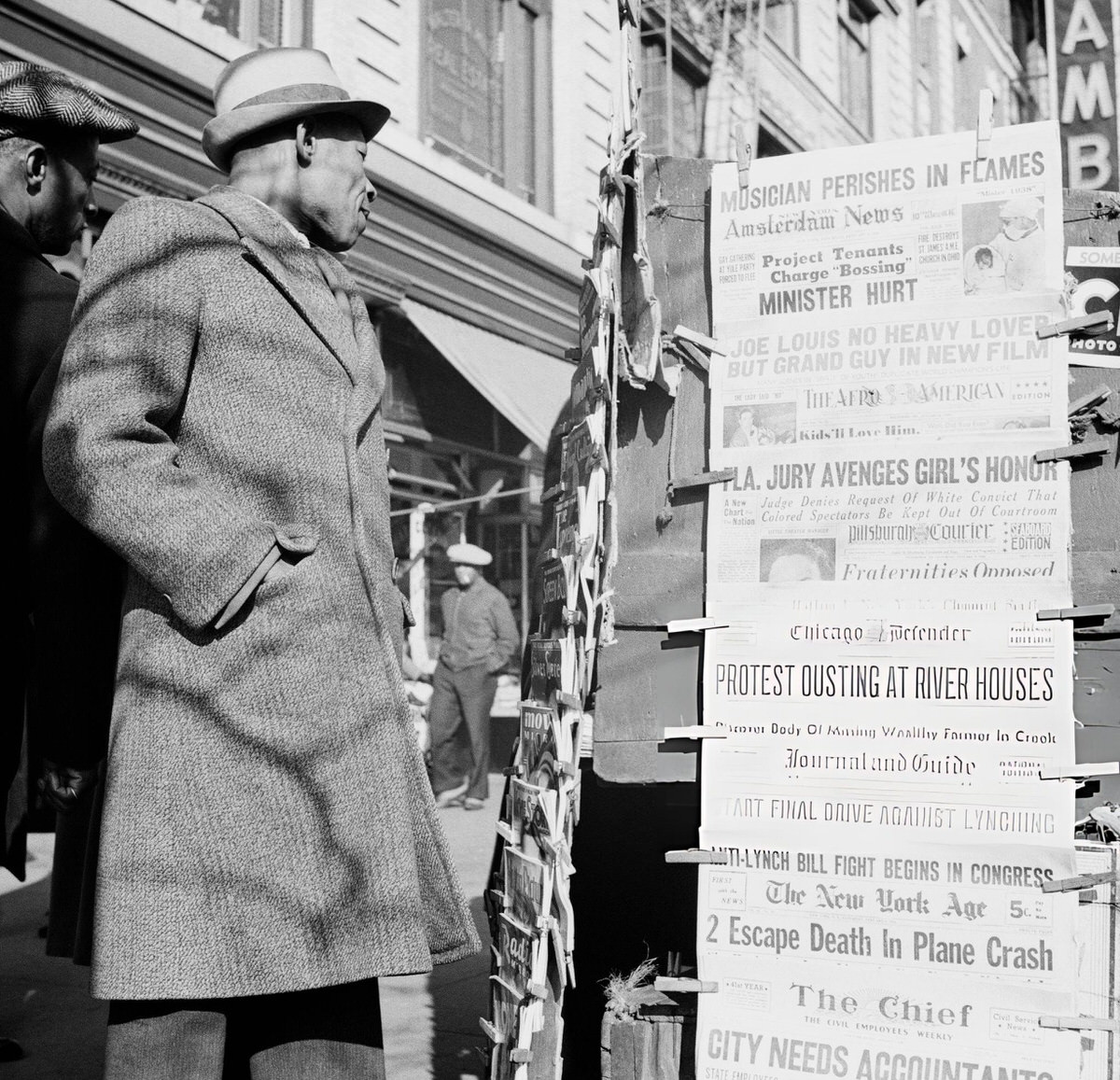 Man Passing A Newspaper Stand.