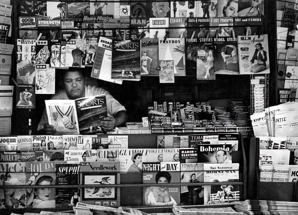 Vendor Reading Sports Illustrated At A Newsstand, New York, 1954.
