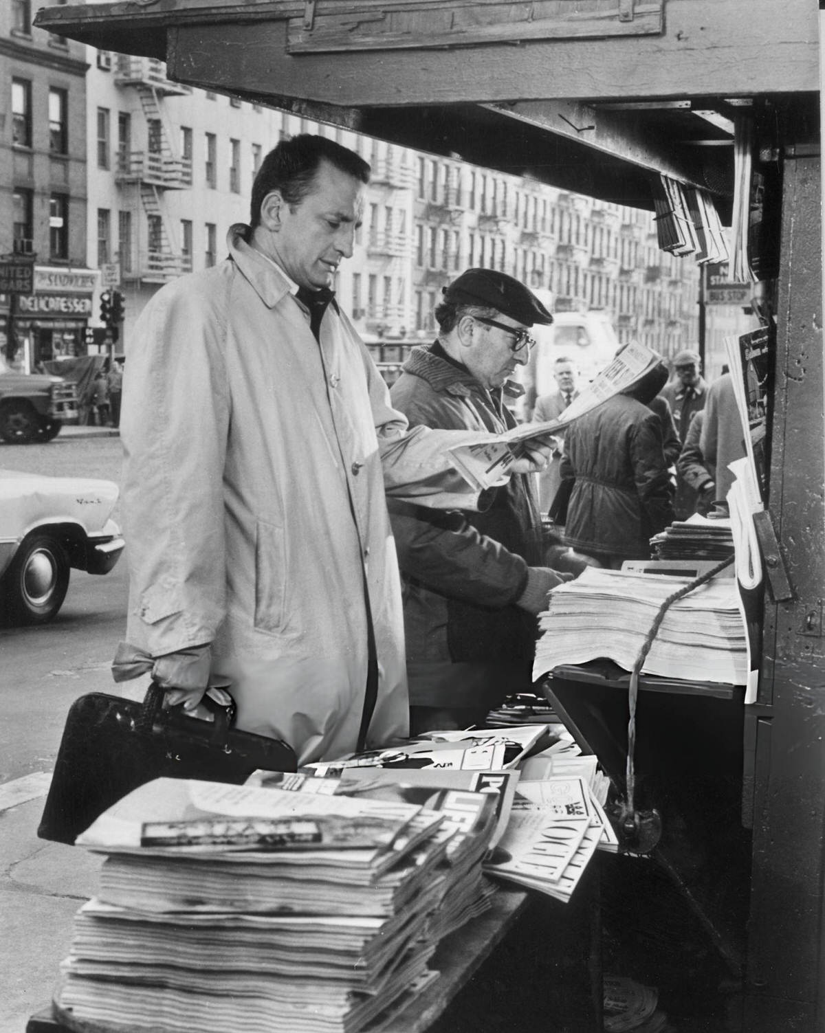 George C. Scott Reading A Newspaper At A Newsstand, East Side/West Side, 1963.