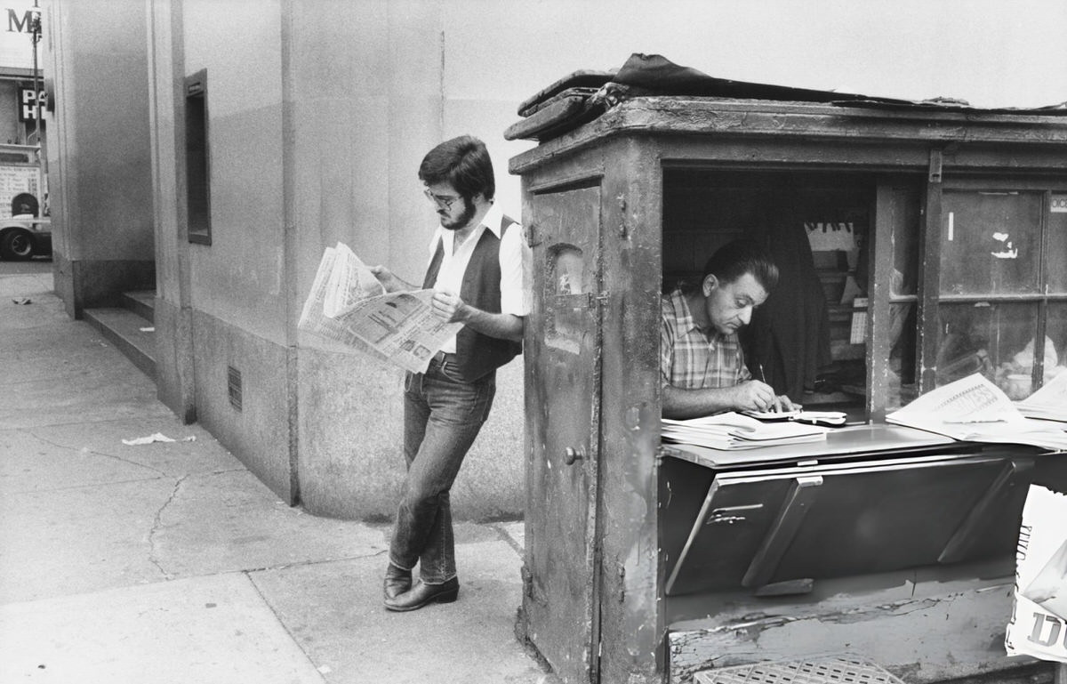 Man Reading A Newspaper At A Newsstand, New York, 1979.
