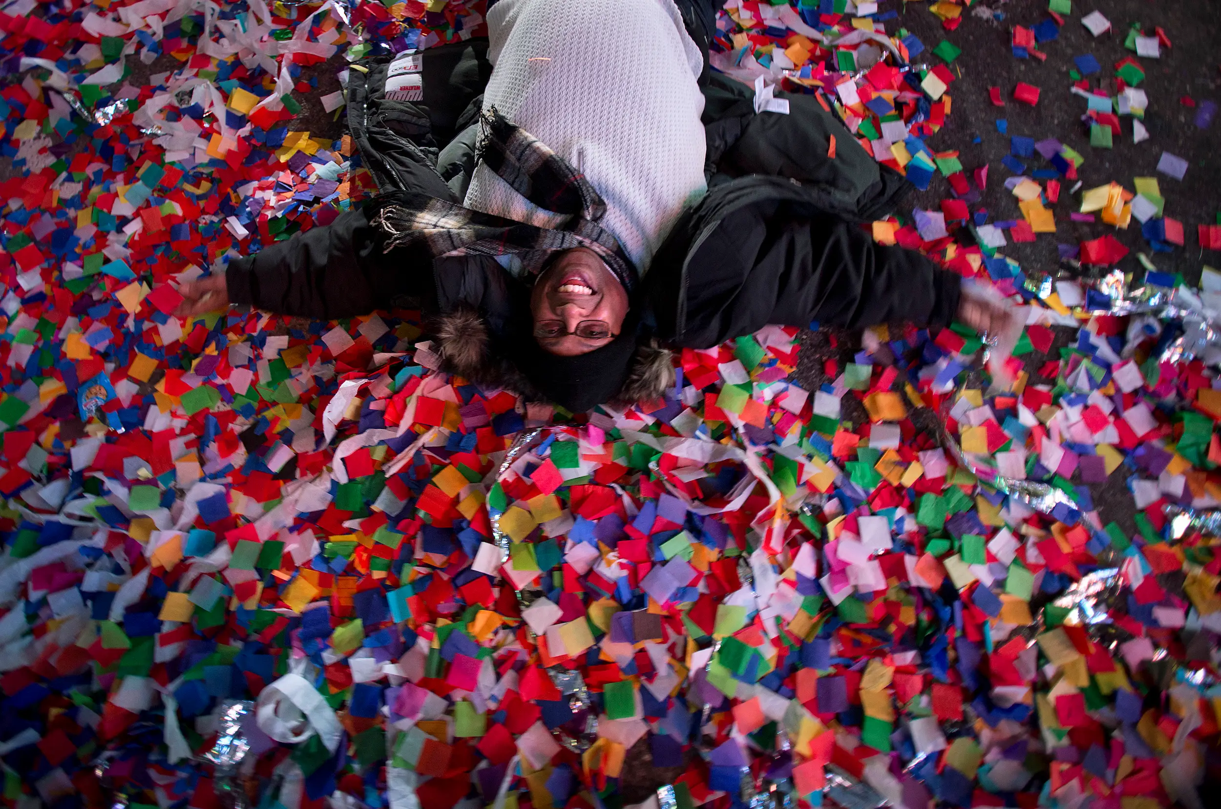 A Reveler Makes Angels In The Confetti On The Ground During New Year'S Eve Celebrations In Times Square On January 1, 2014