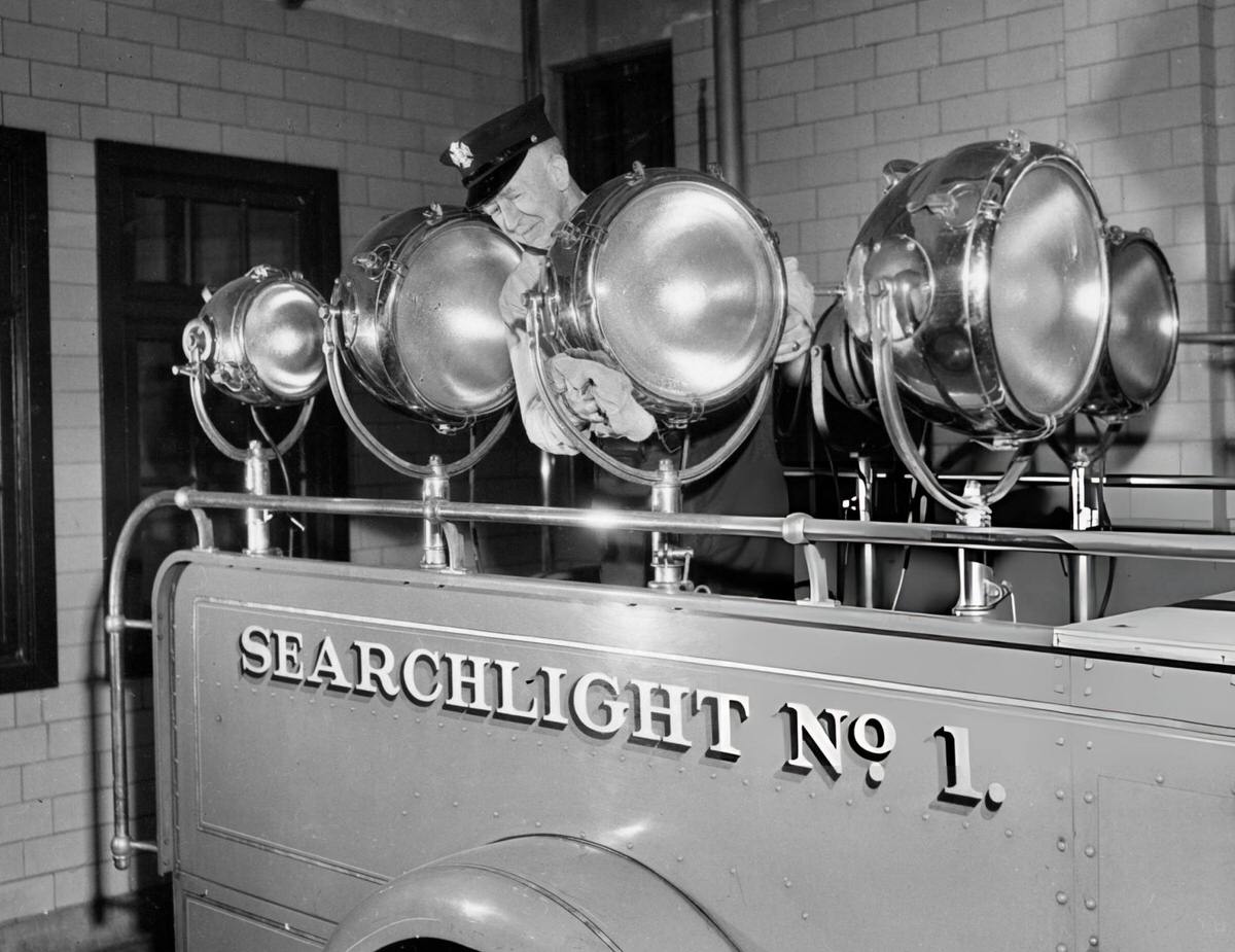 Man Cleaning Firetruck Spotlights, New York, 1940.