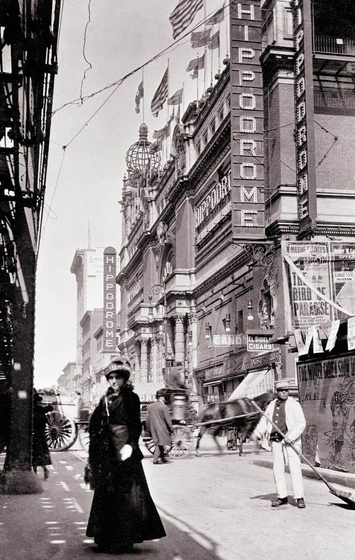 Pedestrians And Horse-Drawn Wagons Passing The New York Hippodrome Under The Sixth Avenue Elevated, 1908.